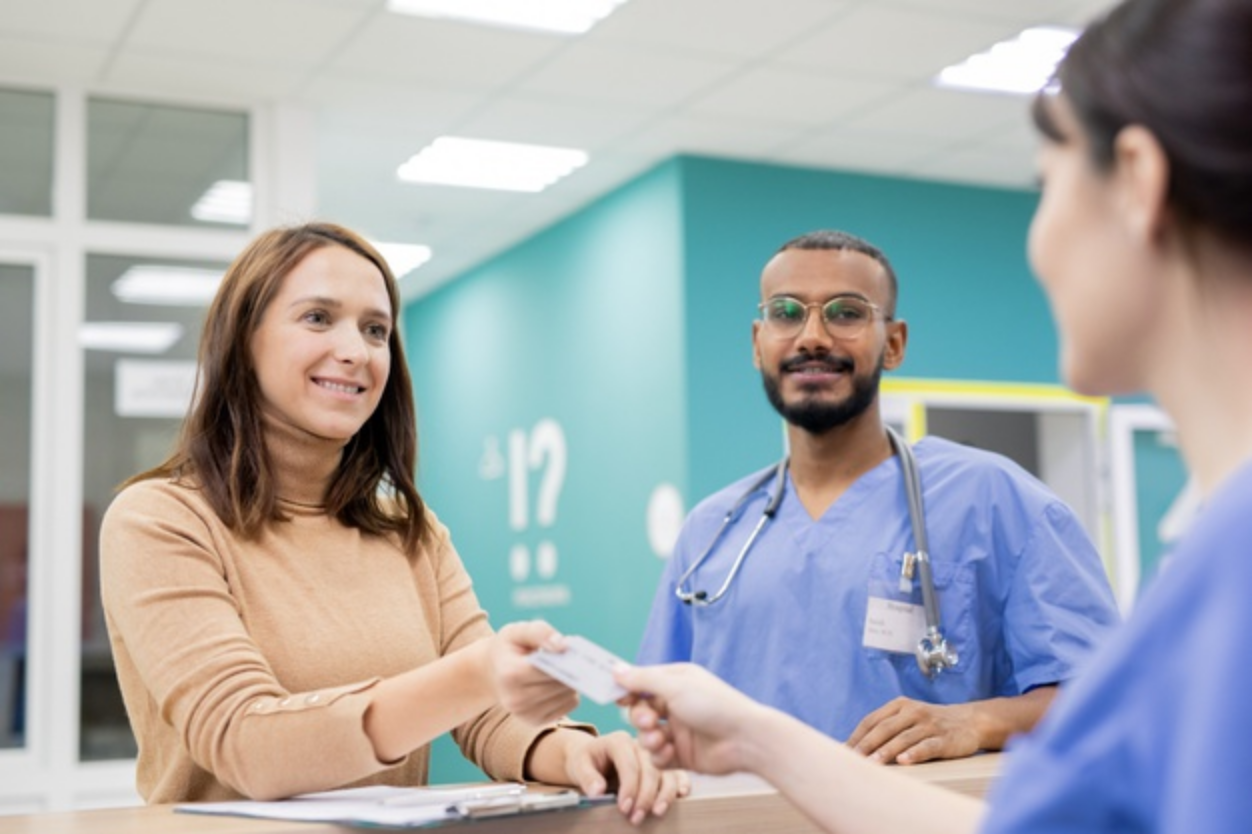 woman-paying-via-credit-card-at-hospital-reception