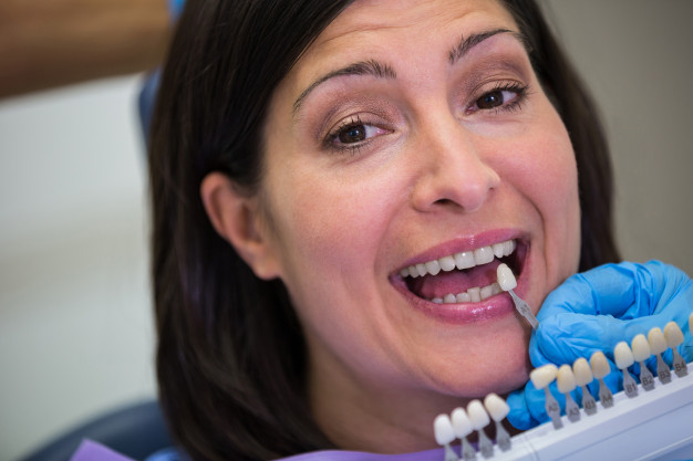 dentist-choosing-tooth-shade-woman-patient